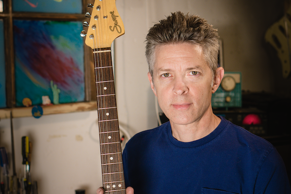 Portrait of Chris holding a guitar